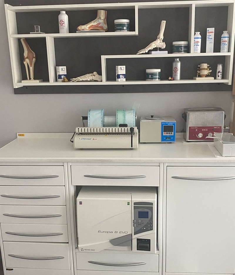 Area sterilizzazione con autoclave Europa B EVO, termosigillatrice, vasca a ultrasuoni e modelli di piede su mensole